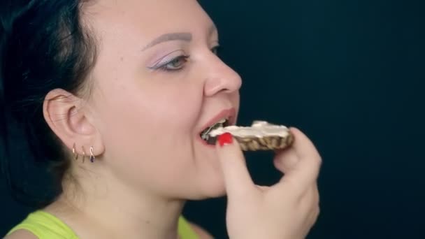 Una giovane donna dopo una dieta affamata con un appetito mangia un panino al formaggio cremoso ad alto contenuto calorico — Video Stock