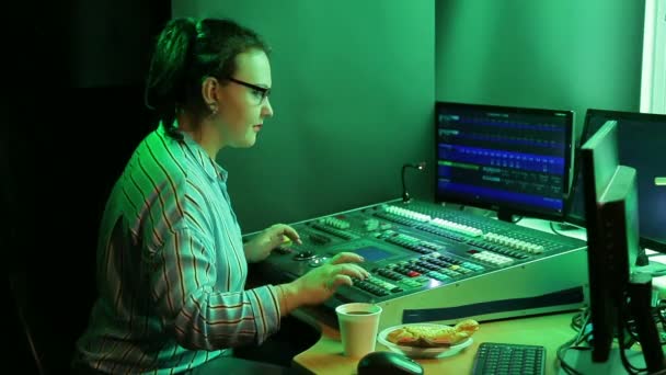 Ung kvinna i glasögon ingenjör Illuminator programmerar ljuset för showen. — Stockvideo