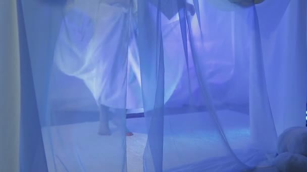 A young bride is dancing on the eve of the wedding behind a white curtain — Stockvideo