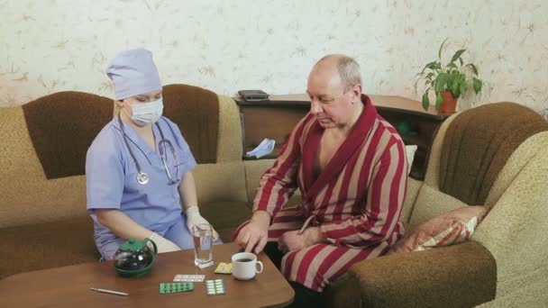 自宅で医者の監督の下で不健康な男が薬を飲んでいる — ストック動画
