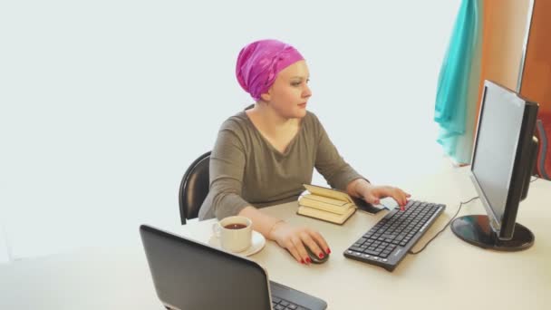 A Jewish woman in a headdress in an office is working on a computer — Stock Video