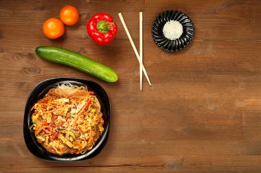 Funselli siyah tabak ve sebzeli tavuk ahşap masa ve taze sebzeler..