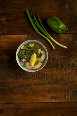 Hafif bir tabak Vietnam Pho çorbası ve ahşap bir masada tavuk..