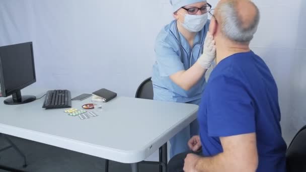 Una doctora examina a un hombre con un virus sospechoso . — Vídeos de Stock