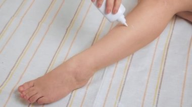 Evde bir kadın tüy dökücü yapıyor. Peruklara talk pudrası serpiyor.