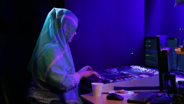 Muslim woman in hijab and glasses engineer programmer programming the light for the show and drinking coffee — Stock Video