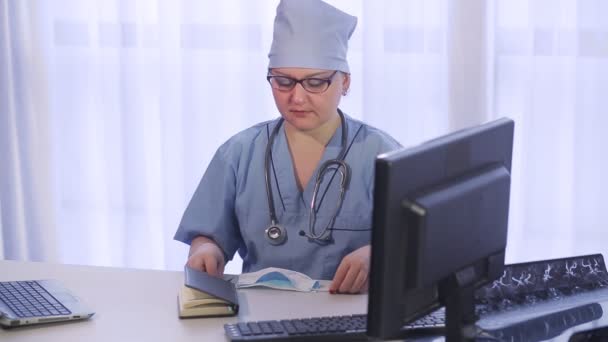 Uma médica no consultório prepara-se para receber doentes. . — Vídeo de Stock