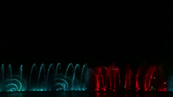 Eine nächtliche Show von Springbrunnen, die sich im Wasser spiegeln — Stockvideo