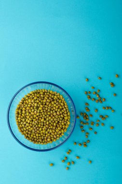 Mavi arka planda yeşil mısır gevreği taneli cam kavanoz..