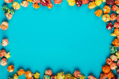 Mavi arka planda dağınık mısır tanecikleri çerçevesi.