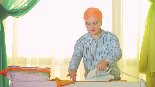 Vrouw strijken wit linnen op een strijkplank — Stockvideo