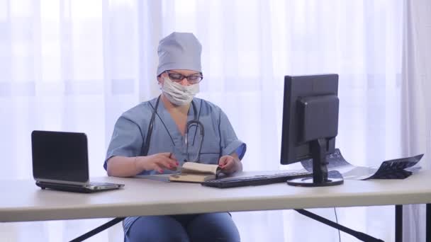 Μια γυναίκα γιατρός στο γραφείο ετοιμάζεται να δεχτεί ασθενείς. — Αρχείο Βίντεο