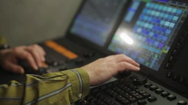 Uzaktan kumandadaki aydınlatma erkek eli şov için sahne ışığını programlar.