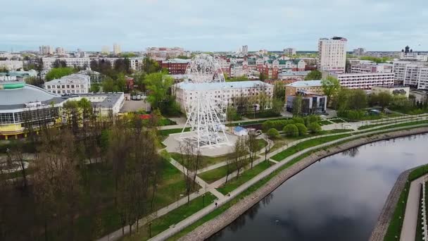 Řeka nábřeží a ruské kolo v centru města se zelenými plochami horní pohled. Panoramatické letecké fotografie — Stock video