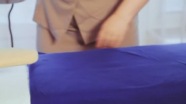 Kadın eli ütü masasında ütü yapar ve ütü yapar.