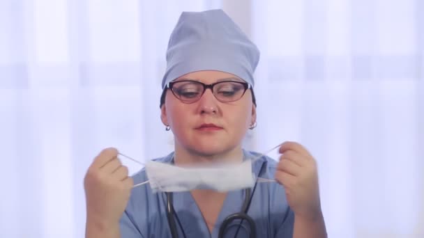 Eine Ärztin spricht über die Notwendigkeit, eine Schutzmaske zu tragen. — Stockvideo