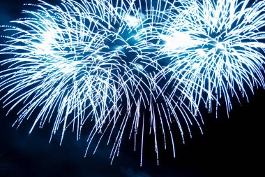 Gece gökyüzünde parlak bir havai fişeğin mavi ışıkları.