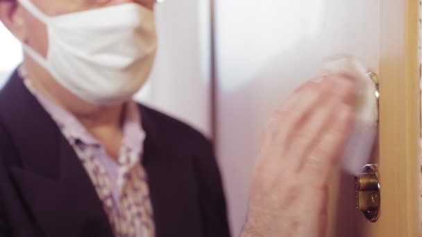 在开始工作前，一名男子用防腐剂对橱柜门把手进行消毒 — 图库视频影像
