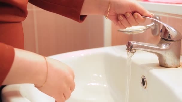 Uma mulher em um lugar público lava as mãos no lavatório com sabão — Vídeo de Stock
