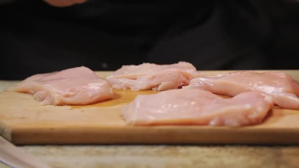 Female hand beats chicken with a metal hammer on a wooden board. — Stock Video