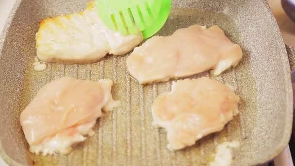Grill tongs overturn fried chicken fillet. Close-up — Stock Video