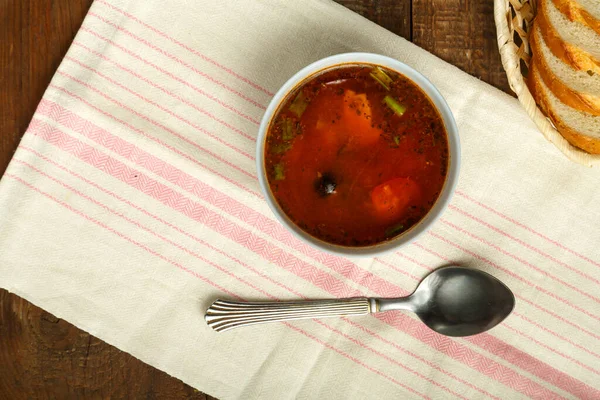 ナプキンとスプーンとパンの木のテーブルの上にジャガイモとキノコとイタリアのトマトスープのカップ. — ストック写真