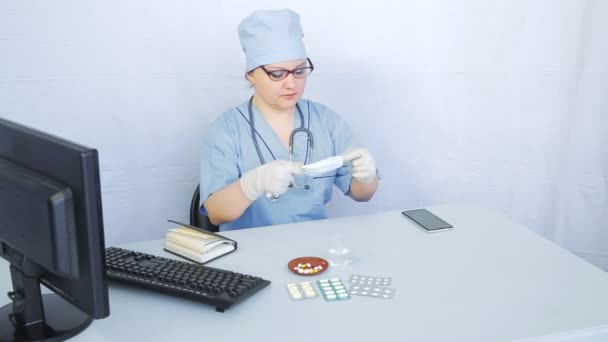 Un medico donna indossa una maschera medica e si mette al lavoro . — Video Stock