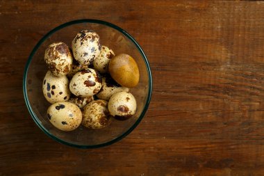 Tabakta bıldırcın yumurtası ve tahta bir masa..