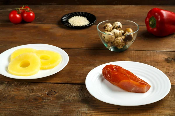 Los ingredientes para una ensalada panasiática son pollo ahumado, piña, huevos de codorniz, tomates y sésamo. —  Fotos de Stock