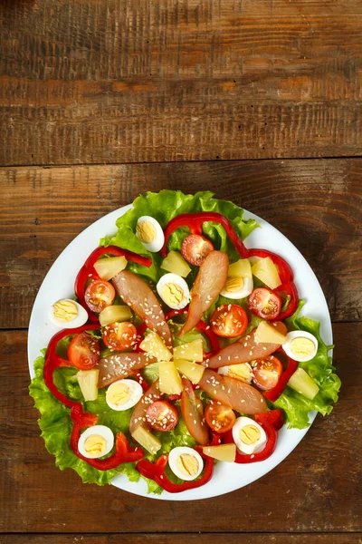 Salade pan-asiatique avec poulet et ananas dans une assiette sur une table en bois sur une serviette . — Photo