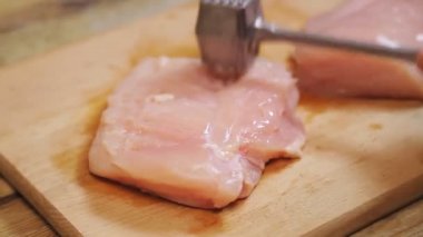 Bir dişi el, tavuğu metal bir çekiçle döver..