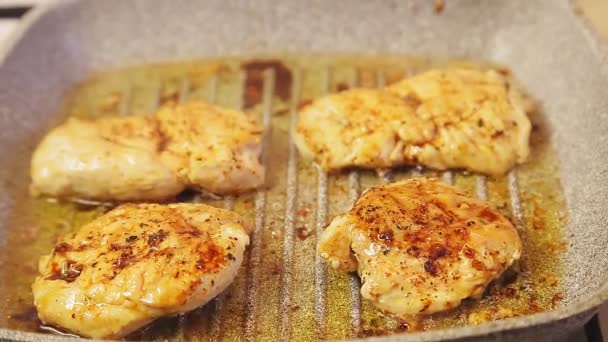 Filete de pollo a la parrilla en aceite chisporroteo . — Vídeo de stock