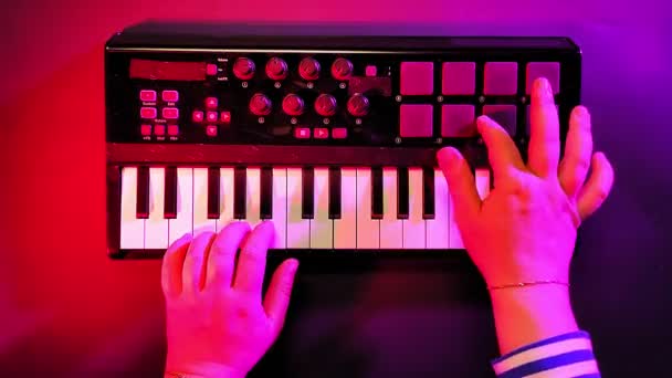 Weibliche Hände spielen auf einer Midi-Tastatur Musik auf — Stockvideo