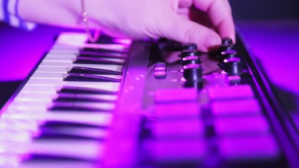 Γυναικεία χέρια παίζουν σε ένα πληκτρολόγιο MIDI και να ρυθμίσετε τον τόνο και τον ήχο. — Αρχείο Βίντεο