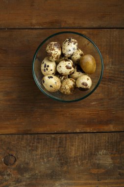 Tabakta bıldırcın yumurtası ve tahta bir masa..