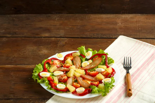 Pan-Aziatische salade met kip en ananas in een bord op een houten tafel op een servet. — Stockfoto