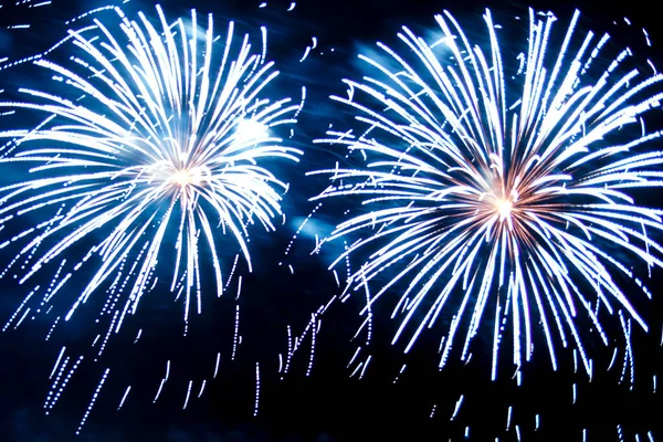 Gece gökyüzünde parlak havai fişeklerin mavi kıvılcımları.