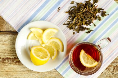 Limonlu, ballı, zencefilli ve peçeteye serpiştirilmiş bir fincan çay..