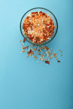 Mavi arka planda sarı mercimek bulunan cam kavanoz..