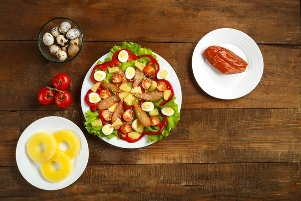 Pan-Asian salad with cherry tomatoes, smoked chicken, pineapple and sesame seeds. Horizontal photo