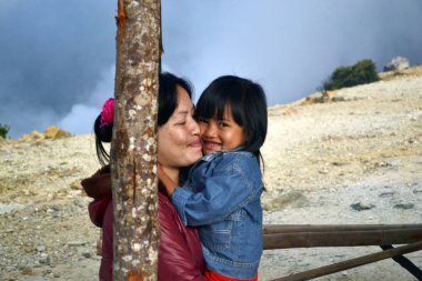 Bir anne ve sevimli kızı. Mount Papanda kadın oturuyor