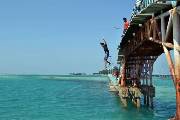 Un turista salta desde el llamado "Puente del Amor" en Tidung Islan —  Fotos de Stock