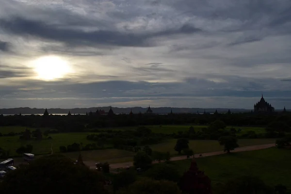 Puesta de sol alrededor de templos que se dispersaron en Bagan Zon Arqueológico — Foto de Stock