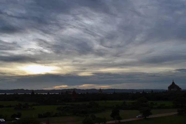 Puesta de sol alrededor de templos que se dispersaron en Bagan Zon Arqueológico — Foto de Stock