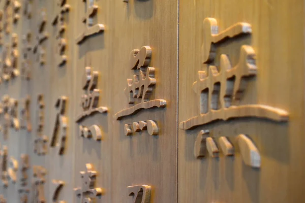 As letras chinesas esculpidas na parede de madeira — Fotografia de Stock