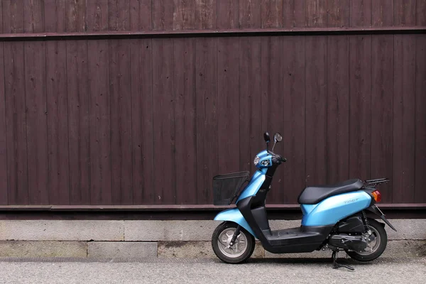 Een motorfiets geparkeerd voor houten muur in Takayama — Stockfoto