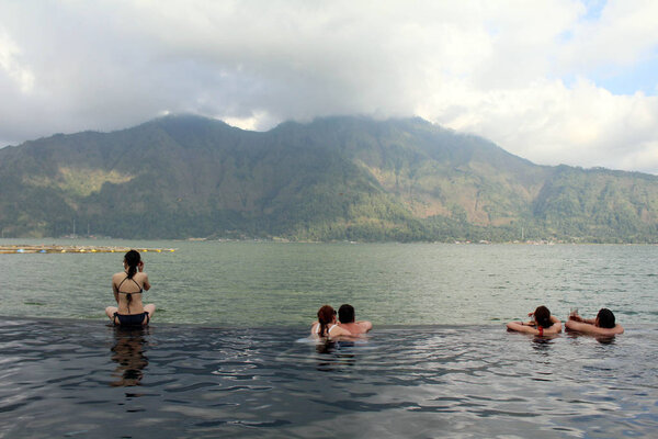 People are enjoying dipping in a hotspring (Toya Devasya), by th