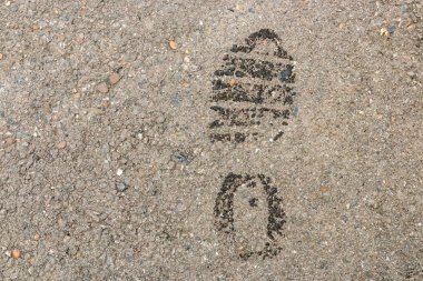 Asfalt yüzeyinde ıslak ayak izleri. Uyarı - hırsız