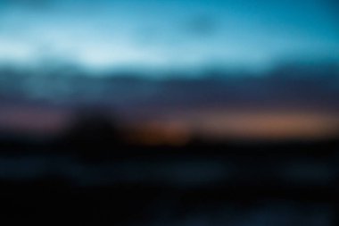 blurred blue sky at twilight with toptrees