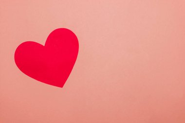 Pembe zemin üzerinde bir kırmızı el işi kağıt kalp kopyalama alanı ile